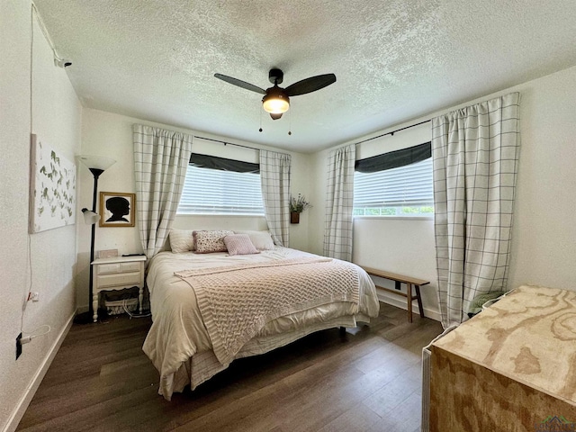 bedroom with dark wood-type flooring, a textured ceiling, and ceiling fan