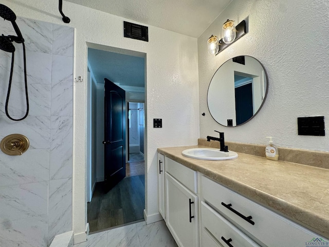 bathroom featuring vanity and a tile shower