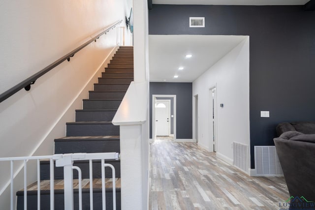 stairway featuring wood finished floors, visible vents, and recessed lighting