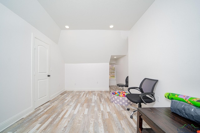 unfurnished office featuring recessed lighting, vaulted ceiling, light wood finished floors, and baseboards