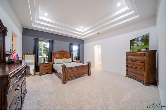 bedroom featuring recessed lighting, a raised ceiling, and light carpet