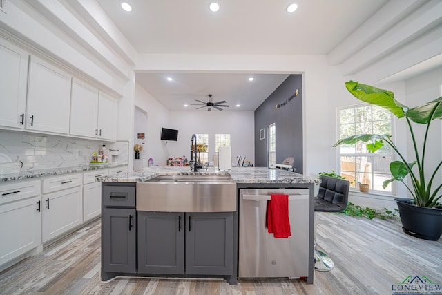 kitchen with recessed lighting, light wood-type flooring, white cabinets, and stainless steel dishwasher