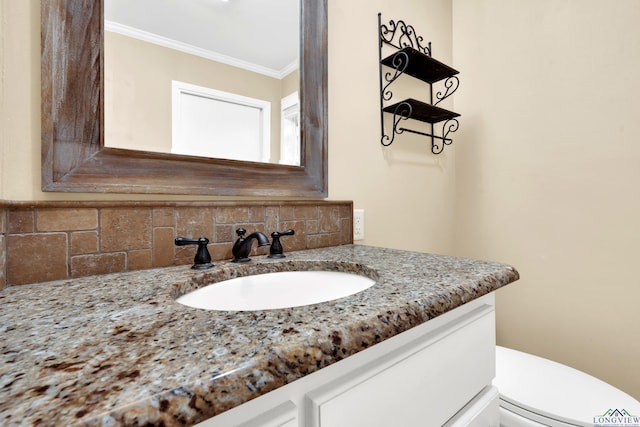 bathroom with backsplash, crown molding, vanity, and toilet