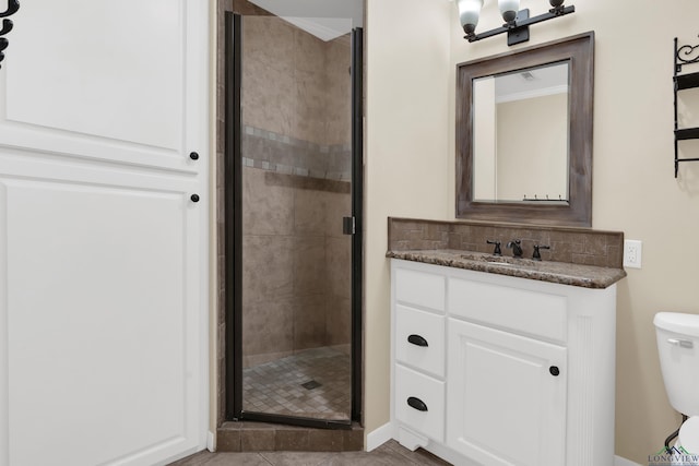 bathroom featuring decorative backsplash, an enclosed shower, vanity, tile patterned flooring, and toilet