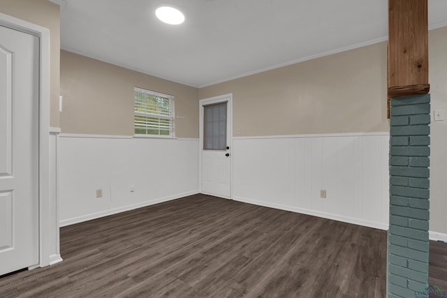 empty room featuring dark hardwood / wood-style flooring and crown molding