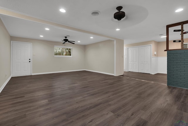 unfurnished living room featuring ceiling fan and dark wood-type flooring