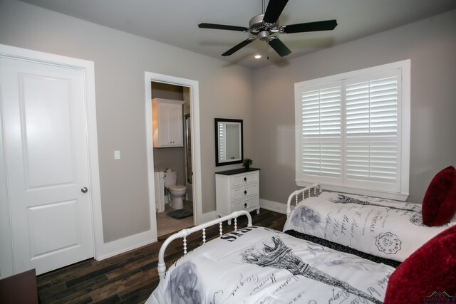 bedroom with ensuite bathroom, dark wood-type flooring, and baseboards