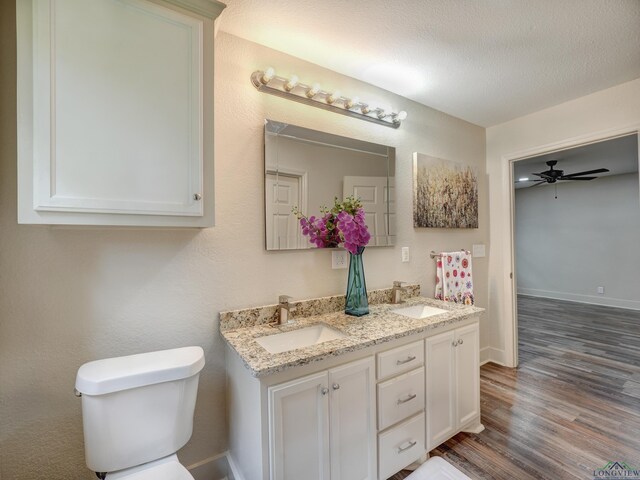 3902 Hazel St, Texarkana, TX 75503 - full bath with wood finished floors, toilet, double vanity, baseboards, and ceiling fan