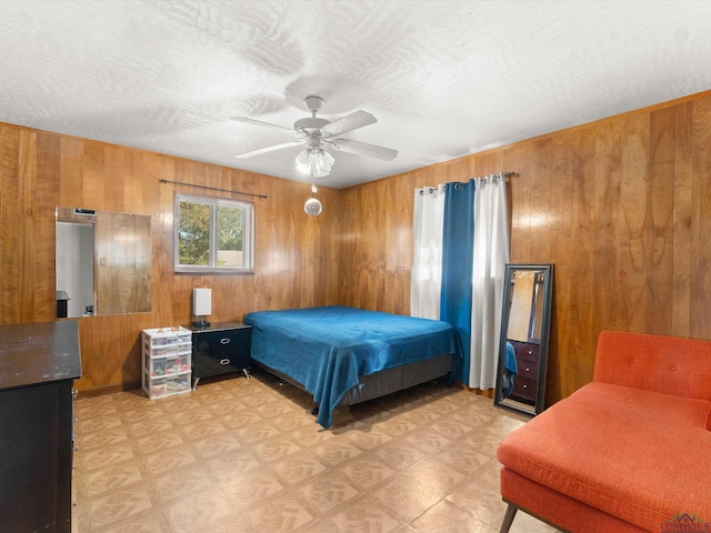 bedroom featuring ceiling fan and wood walls