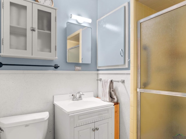 bathroom with vanity, toilet, and a shower with shower door