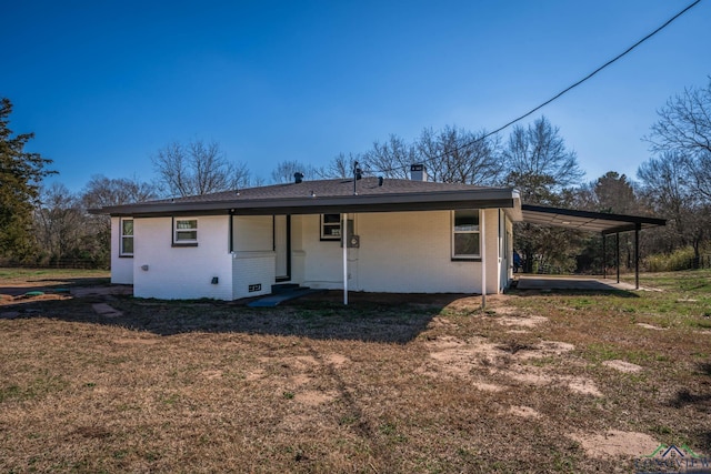 rear view of property with a yard and a carport