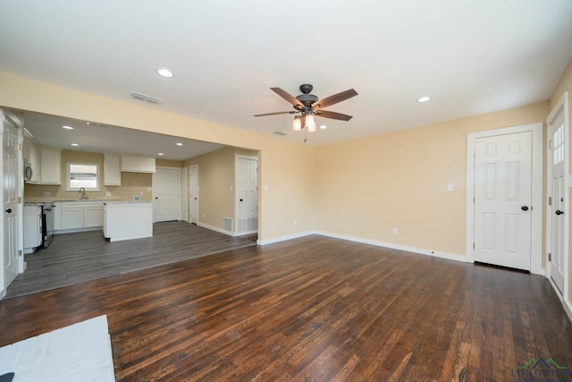 unfurnished living room featuring ceiling fan, sink, and dark hardwood / wood-style floors