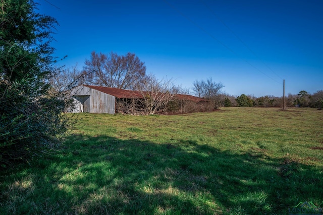 view of yard featuring an outdoor structure and a rural view