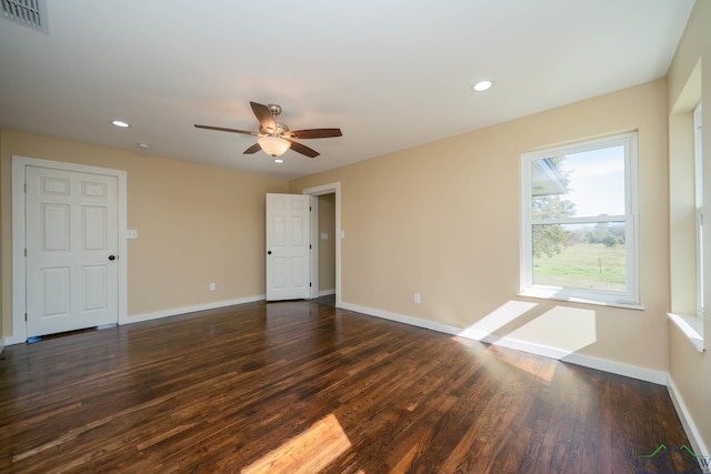 spare room with dark wood-type flooring and ceiling fan