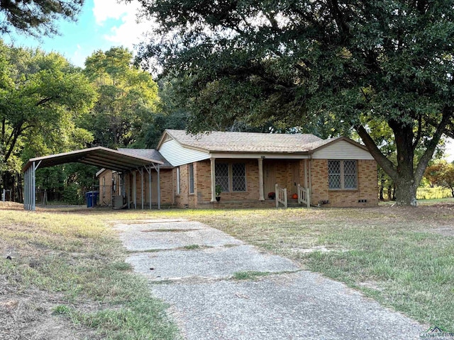 ranch-style home featuring a front lawn and a carport