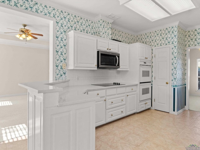 kitchen featuring white cabinetry, white double oven, kitchen peninsula, and crown molding