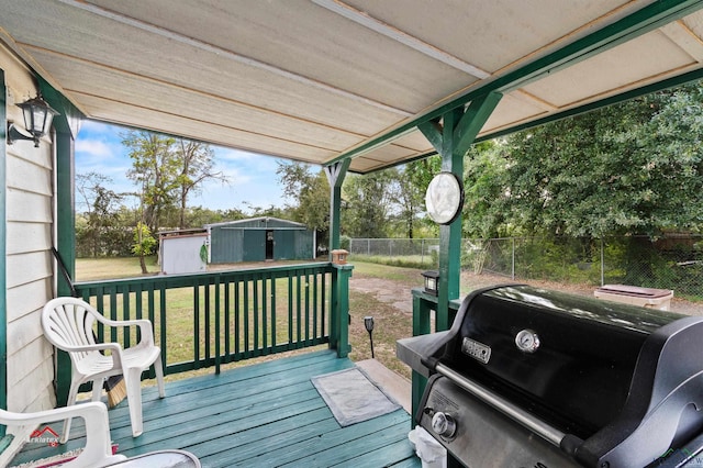 wooden deck featuring area for grilling, a storage shed, and a yard