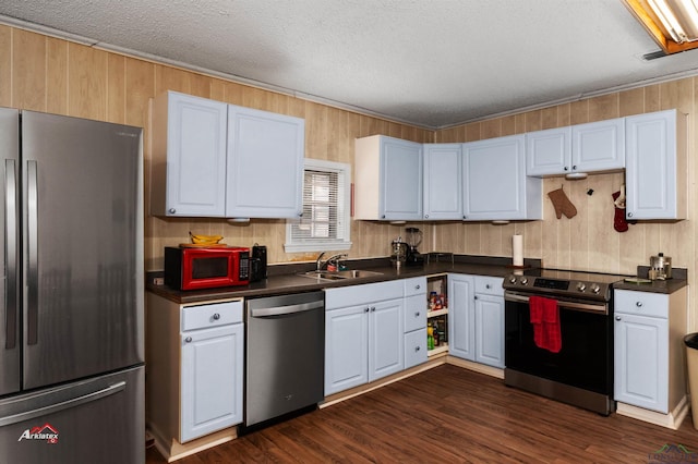 kitchen with sink, dark wood-type flooring, a textured ceiling, white cabinets, and appliances with stainless steel finishes