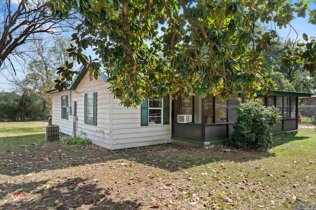 view of home's exterior with a lawn, central AC, a sunroom, and cooling unit