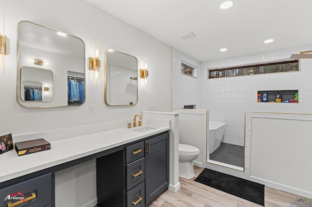 full bathroom with hardwood / wood-style flooring, vanity, toilet, and separate shower and tub