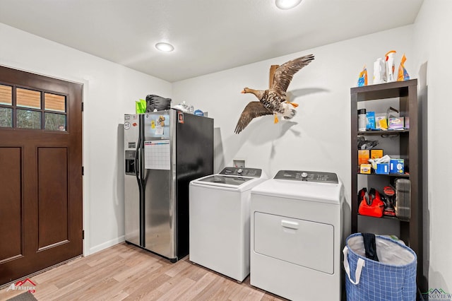 laundry area featuring separate washer and dryer and light hardwood / wood-style flooring