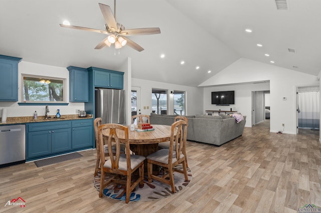 dining room featuring ceiling fan, sink, high vaulted ceiling, and light hardwood / wood-style flooring