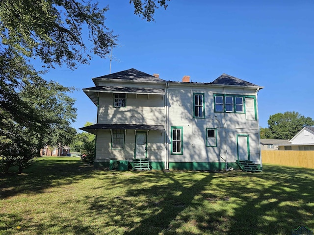 rear view of property featuring a yard