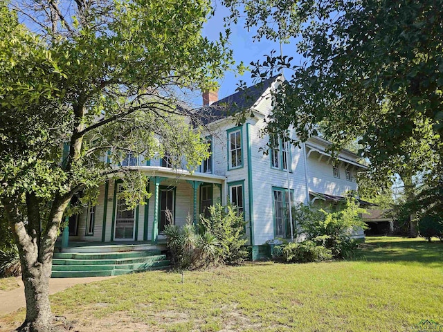 view of front of house with a porch and a front lawn