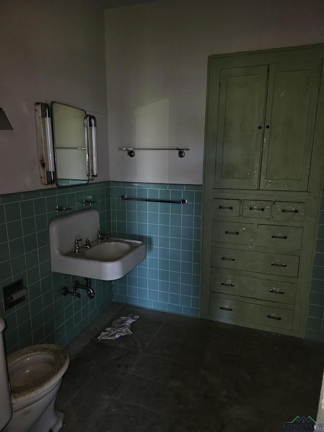 bathroom with tile patterned floors, sink, tile walls, and toilet