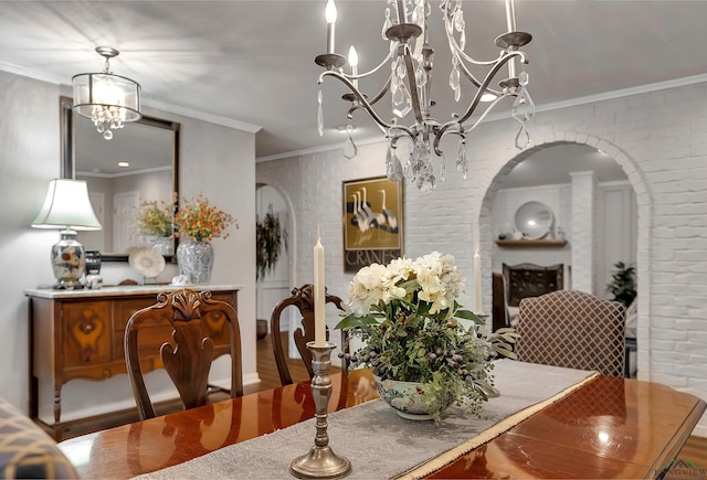 dining room with ornamental molding, brick wall, and a notable chandelier