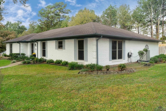 view of front of home with cooling unit and a front yard