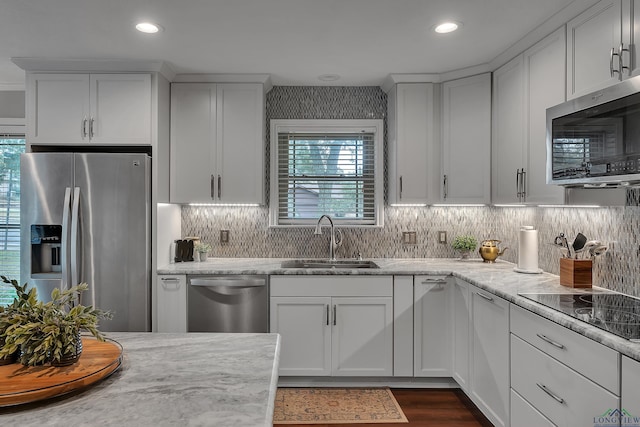 kitchen with appliances with stainless steel finishes, sink, and white cabinets