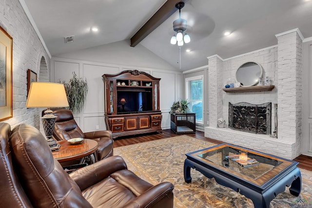 living room with dark hardwood / wood-style floors, a fireplace, vaulted ceiling with beams, ornamental molding, and ceiling fan