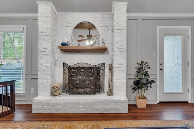 room details featuring crown molding, ceiling fan, hardwood / wood-style floors, and a brick fireplace