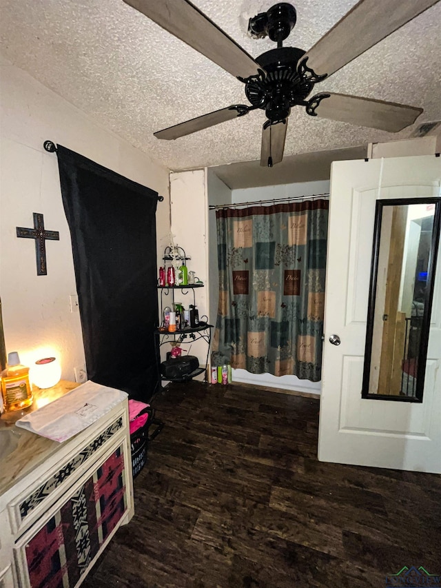 kitchen featuring ceiling fan, a textured ceiling, and dark hardwood / wood-style floors