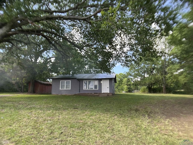 1407 E US-80, White Oak, TX 75693 - view of front of home featuring a front lawn and metal roof