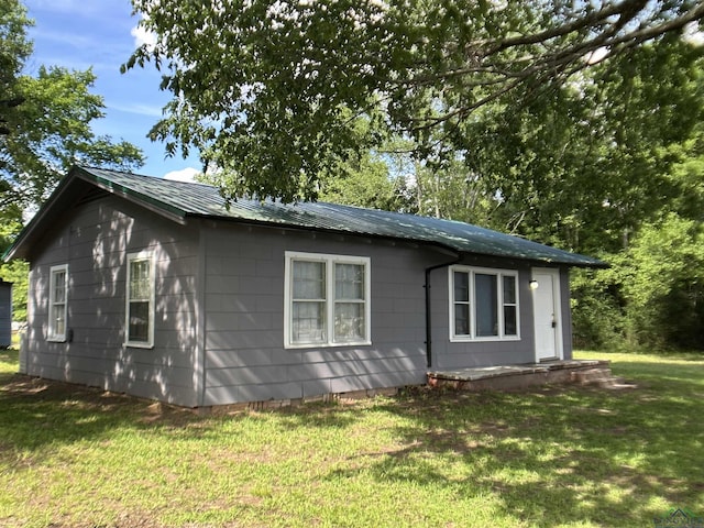 1407 E US-80, White Oak, TX 75693 - view of side of home featuring a yard and metal roof