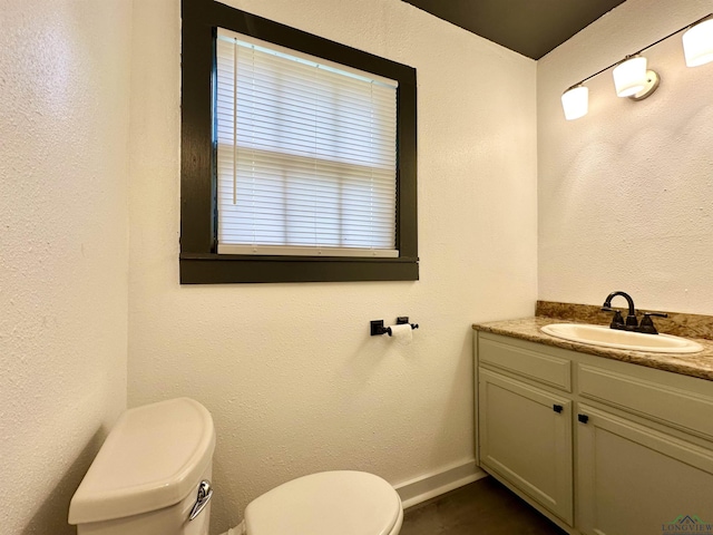 1407 E US-80, White Oak, TX 75693 - half bathroom featuring toilet, vanity, and baseboards