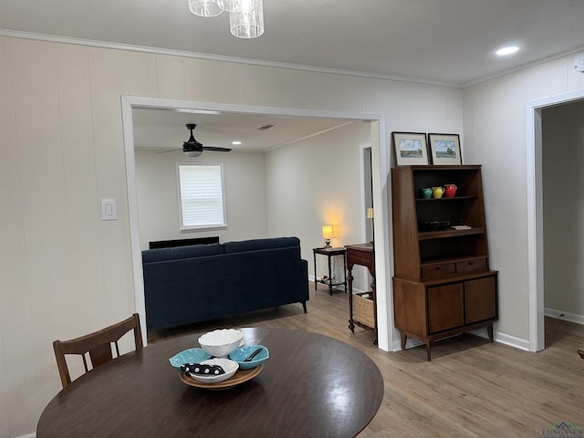 dining space with crown molding, wood finished floors, baseboards, and ceiling fan