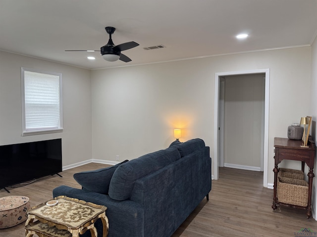 living room featuring visible vents, a ceiling fan, baseboards, and wood finished floors