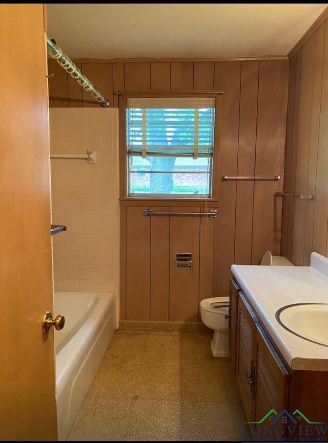 full bathroom featuring vanity, toilet, tub / shower combination, and wood walls