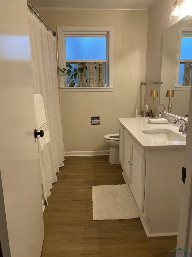 full bathroom featuring toilet, curtained shower, wood finished floors, crown molding, and vanity