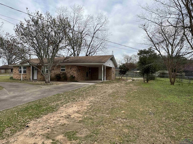 view of front facade with driveway, brick siding, a front lawn, and fence