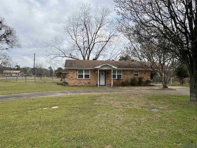 single story home featuring a front lawn, fence, brick siding, and driveway