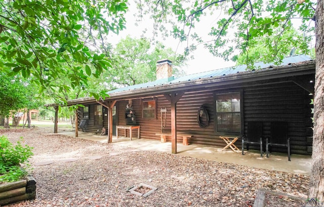 325 Laurel Ln, Holly Lake Ranch, TX 75765 - rear view of property featuring a chimney, a patio, metal roof, and log exterior