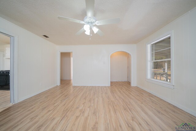 spare room featuring a textured ceiling and light hardwood / wood-style flooring