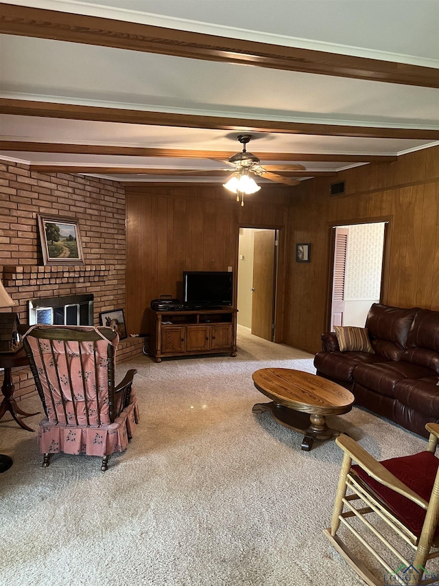 living area with ceiling fan, visible vents, light colored carpet, wood walls, and beamed ceiling