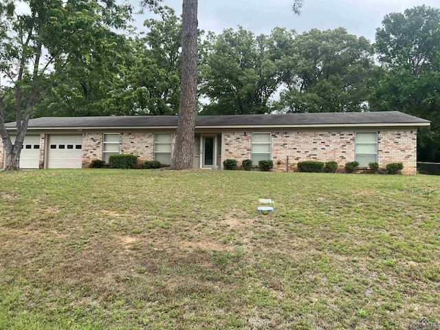 ranch-style house with brick siding, an attached garage, and a front yard