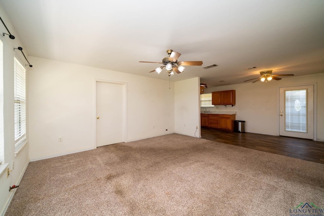 620 County Road 3332, Omaha, TX 75571 - unfurnished living room featuring a sink, visible vents, a ceiling fan, and dark colored carpet