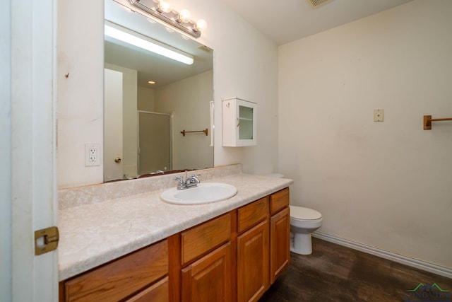 620 County Road 3332, Omaha, TX 75571 - full bath featuring vanity, baseboards, a stall shower, toilet, and wood finished floors